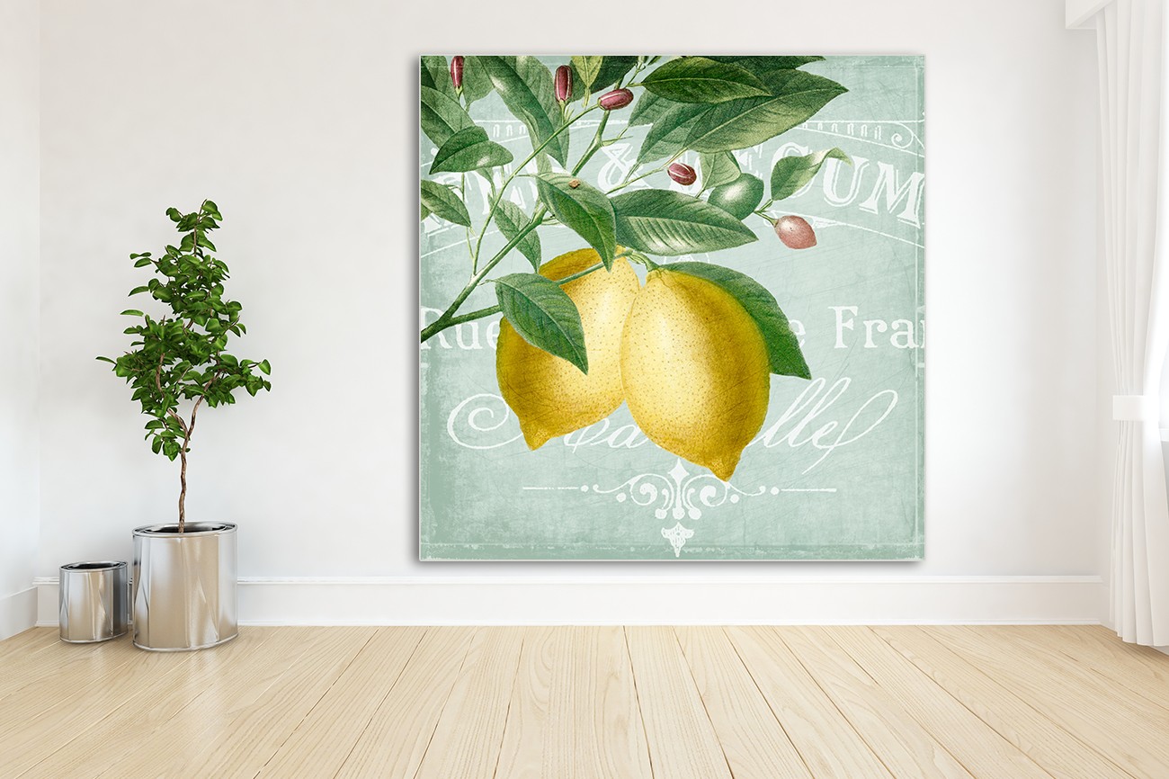 Schilderij met twee citroenen op de voorgrond aan bladeren en takken op een licht blauwe achtergrond van Kimberly Allen met als titel Lemon drop 2 op textieldoek. 