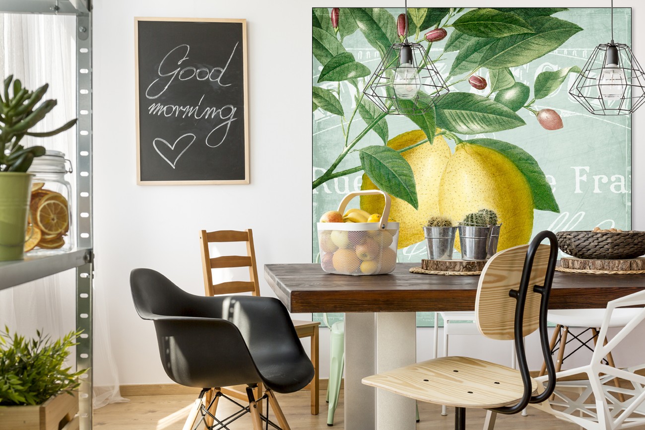 Schilderij met twee citroenen op de voorgrond aan bladeren en takken op een licht blauwe achtergrond van Kimberly Allen met als titel Lemon drop 2 op textieldoek.